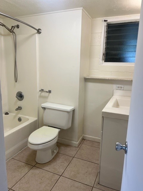 A white toilet in a small bathroom with a shower.